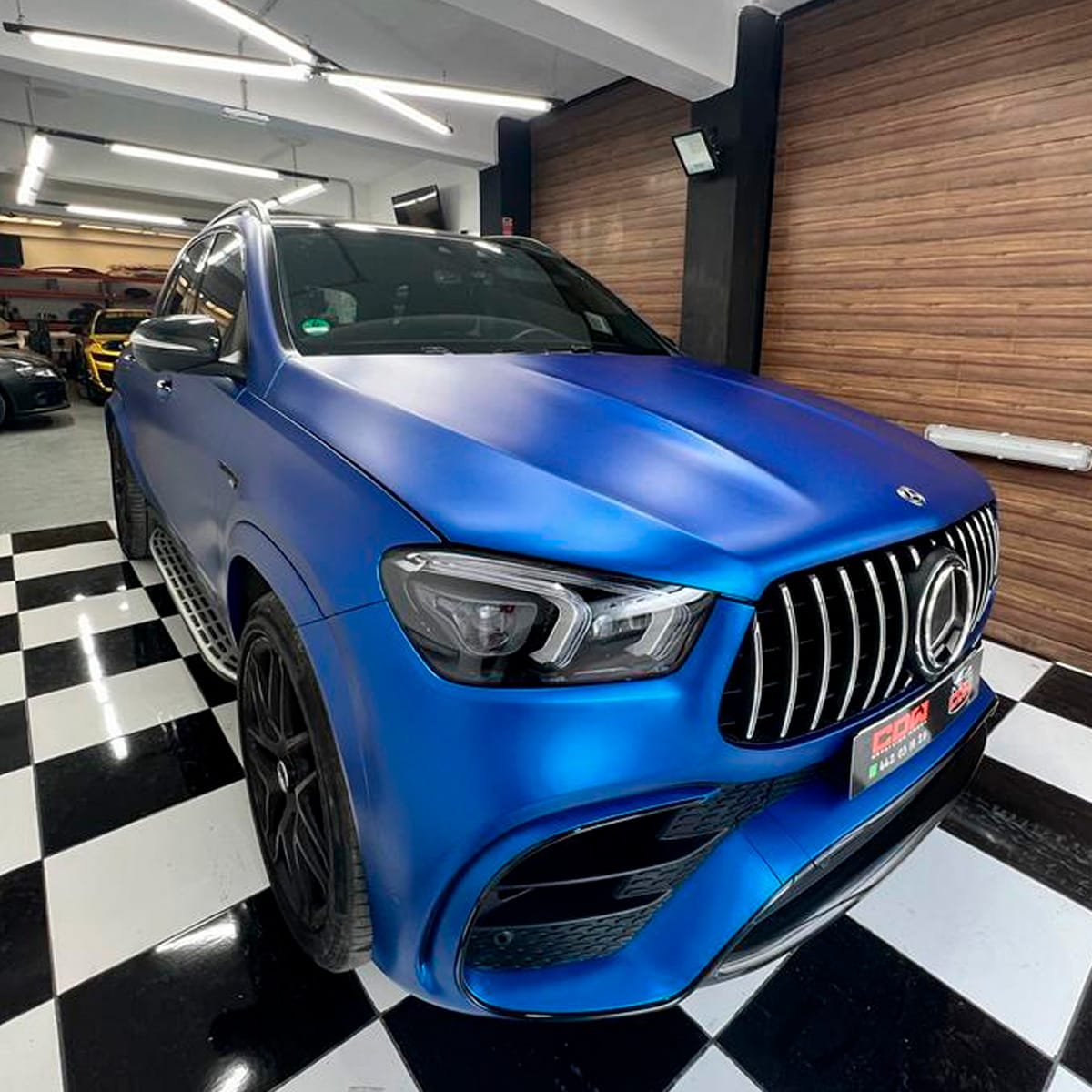 Mercedes SUV con vinilo azul satinado sobre suelo ajedrezado; cambio de color profesional en CDW llacer