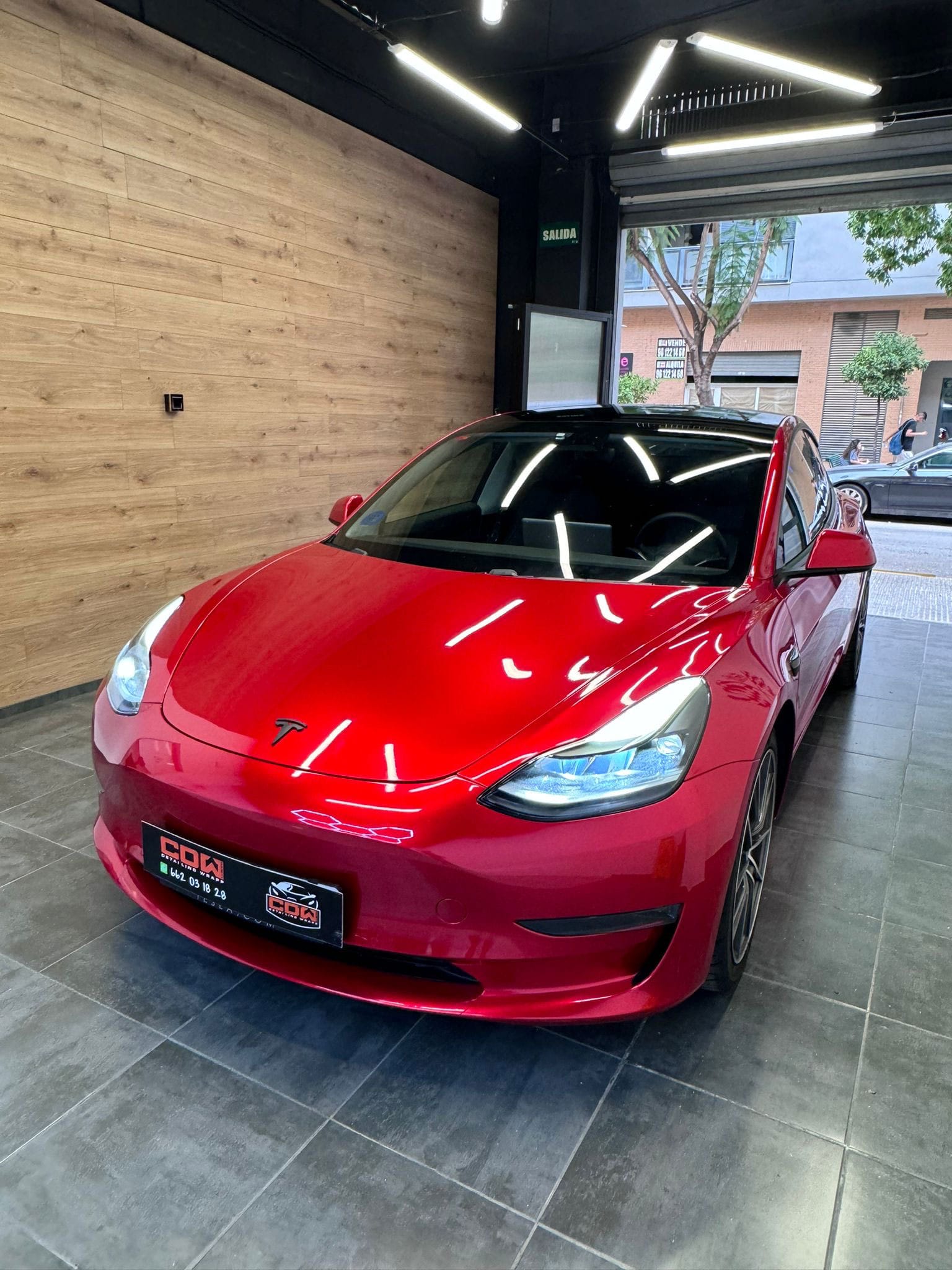 Tesla Model 3 rojo preparado en el taller CDW Llacer, acabado de alto brillo y box de iluminación.