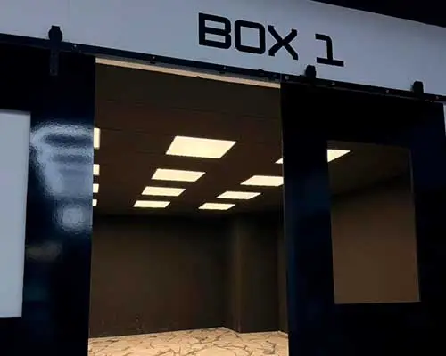 Entrada del Box 1 del taller con iluminación interior preparada para trabajos de wrapping y detailing